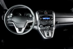 Gros plan sur l'intérieur d'une voiture moderne à Chambly, mettant en valeur le volant, le tableau de bord avec cadrans éclairés, la console centrale et le système audio numérique. Les touches noires et argentées lui confèrent une allure élégante, idéale pour ceux qui recherchent une assurance auto.