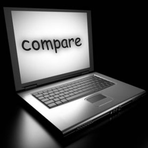 Un ordinateur portable avec le mot « comparer » affiché sur son écran, sur un fond sombre.