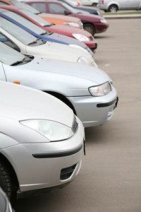 Plusieurs voitures sont garées côte à côte dans un parking, présentées de face et en vue d'angle, avec différentes couleurs, notamment l'argent, le blanc, le rouge et le bleu.